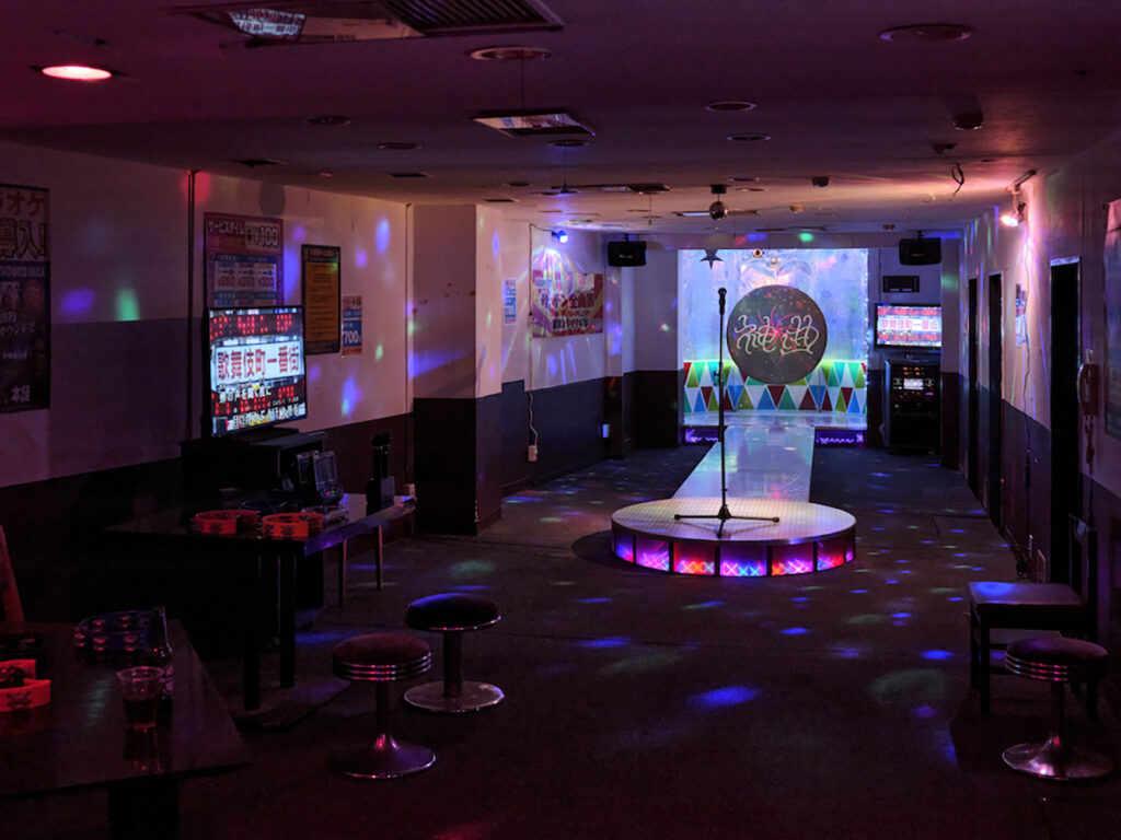 ＜4階＞ 「神曲 ― La Divina Commedia」2023, カラオケのパーティールーム、マルチメディア,  かつてカラオケ居酒屋として一世を風靡した王城。「402号室」をカラオケのパーティールームとしてリノベーション。 正面玄関受付でルームナンバーが明記されたバインダーを受け取った観客は、全員カラオケ歌い放題。（撮影：森田兼次）