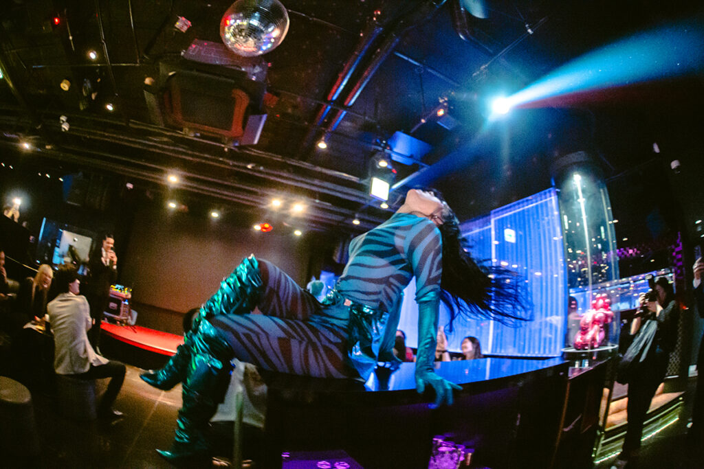 プログラム：AWAKE(F)-①Fancy Fantasy! by FAMEME｜FAMEME初の日本語シングル《Fancy Fantasy!》の一般公開を記念し、歌舞伎町の大型ビジョンにてミュージックビデオをお披露目するほか、新宿・歌舞伎町でホストクラブや飲食店などを展開する「Smappa!Group」が2018年にオープンしたホストクラブ「AWAKE」にて、2024年7月に実施しFAMEME旋風を巻き起こしたイベント「Fancy Fantasy! by FAMEME」のポップアップを実施する。いかなるジェンダーも受け入れる期間限定のポップアップホストクラブにて、異性愛規範の疑似恋愛をクィアの視点からときほぐす。（撮影：上原俊）